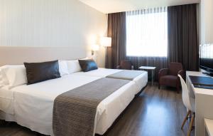 a hotel room with a large bed and a television at Catalonia Gran Hotel Verdi in Sabadell