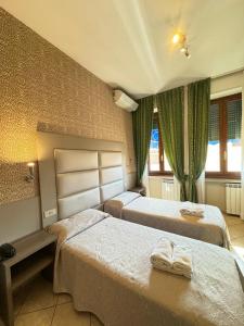 a hotel room with two beds and a window at Hotel Le Querce in Milan