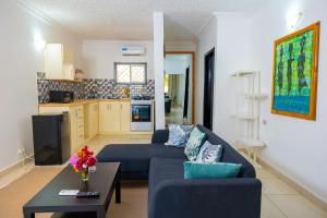 - un salon avec un canapé bleu et une table dans l'établissement Sarges Hotel, à Sere Kunda