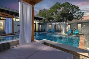 a swimming pool with blue chairs and a house at Resort Style Vacay HeatedPool Hottub and Cabanas in Houston
