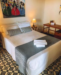 - une chambre avec un lit et des serviettes dans l'établissement Pousada Beija Flor, à Salvador