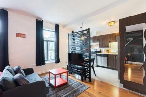 uma sala de estar com um sofá e uma cozinha em The Grand Prix Suite In the heart of MTL - M11 Rentals em Montreal