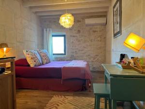 - une chambre avec un lit, une fenêtre et une table dans l'établissement Les Maisons de Fontvieille, à Fontvieille