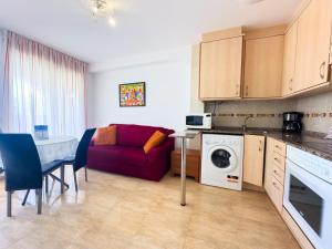 a kitchen and a living room with a red couch at Acogedor apartamento cerca de la playa wifi y parking in Montroig +7 photos