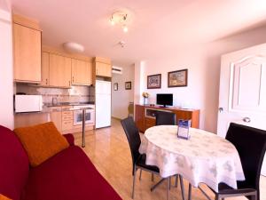 cocina y sala de estar con mesa y sillas en Acogedor apartamento cerca de la playa wifi y parking, en Mont-roig