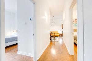a room with white walls and a bedroom with a bed at M11 Stylish & Modern 3BR downtown MTL in Montréal