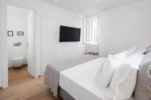 1 dormitorio blanco con 1 cama y TV de pantalla plana en Corfuvacations - Ourania, en Corfú