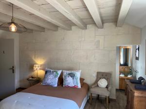 フォンヴィエイユにあるLes Maisons de Fontvieilleの大きなベッドと椅子のある寝室