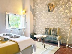 フォンヴィエイユにあるLes Maisons de Fontvieilleのベッドルーム1室(ベッド1台、椅子、窓付)