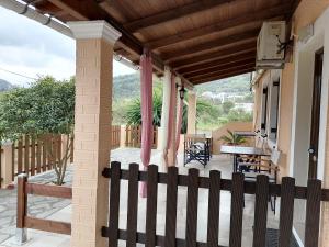 a porch with a wooden fence and a table at Marilena's Beach House in Agios Georgios Pagon