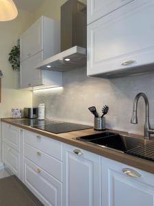 uma cozinha com armários brancos e um lavatório em Casa Riviera em Lavagna