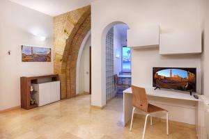 a living room with a table and a tv on a wall at Elehome2 nel cuore della città in Siena +18 photos