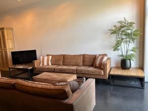 sala de estar con sofá y TV en La Petite Fleur, en Baarle-Nassau