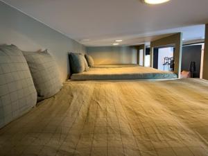 een slaapkamer met een groot bed en een houten vloer bij La Petite Fleur in Baarle-Nassau