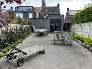 a patio with benches and tables in front of a building at La Petite Fleur in Baarle-Nassau