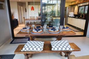 una mesa de madera con platos y vasos. en Condomínio Quinta de Juquehy - Prime Experience en Juquei