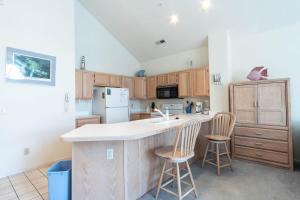a kitchen with a counter and two chairs in it at Tidewater- Teal lake #2521 in North Myrtle Beach