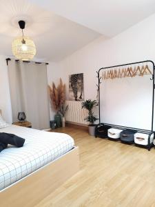 um quarto com uma cama e um grande ecrã em Appartement Confort Tout Équipé - Centre ville em Millau