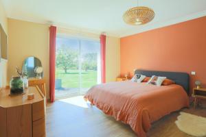 een slaapkamer met een bed en een groot raam bij Villa avec jacuzzi, hammam et sauna in Plestin-les-Grèves