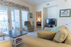 een woonkamer met een bank, een tafel en een tv bij Tidewater Teal Lake 1323 in North Myrtle Beach
