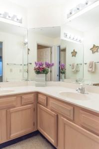 een badkamer met 2 wastafels en een grote spiegel bij Tidewater Teal Lake 1323 in North Myrtle Beach