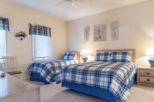 1 dormitorio con 2 camas y ventana en Tidewater Teal Lake 1323 en North Myrtle Beach