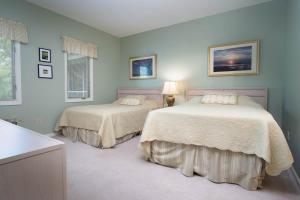 two beds in a bedroom with blue walls at Teal Lake 2323 in North Myrtle Beach