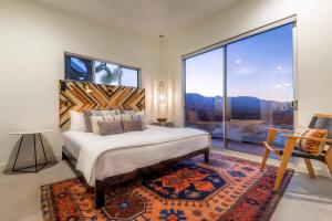 a bedroom with a bed and a large window at Shelter 1- A Classic- At Joshua Tree Park Entrance in Joshua Tree