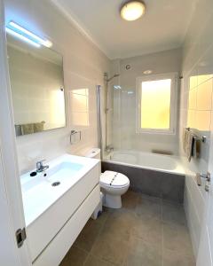 y baño con bañera, aseo y lavamanos. en Villa Azure, en Caleta de Fuste