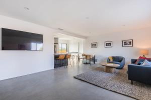 a living room with a couch and a tv on a wall at Hidden Valley Cottage - Modern Home in JT Hot Tub in Joshua Tree