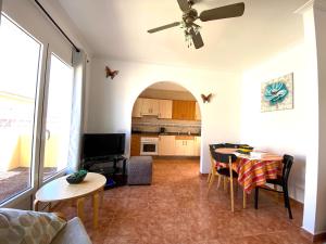 sala de estar con mesa y cocina en Villa Azure, en Caleta de Fuste