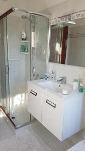 a white bathroom with a shower and a sink at Il Nido di Pikki in Falconara Marittima