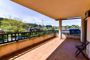 een balkon met een bank en uitzicht op de stad bij Cómodo y espacioso chalet con piscina comunitaria in Miengo