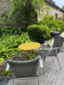 a table and two chairs and a yellow table and chairs at La Grange de Marcel in Saint-Pol-de-Léon +16 photos
