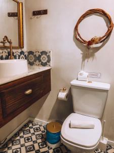 a bathroom with a toilet and a sink and a mirror at Pousada Beija Flor in Salvador +71 photos