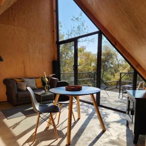 Habitación con mesa, sillas y sofá en Cabañas Grasshopper SHIELD, en Tepoztlán