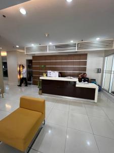 un vestíbulo con una sala de espera con un banco y un mostrador en 1-Bedroom IT Park Avida Cebu, en Cebú