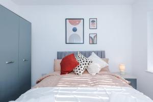 une chambre avec un lit avec des oreillers dessus dans l'établissement Heart Of Didsbury, Private Gated Car Park by HASS HAUS, à Manchester