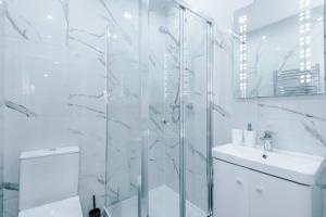 baño blanco con ducha y lavamanos en Brand New Modern 2 Bed in Didsbury en Mánchester