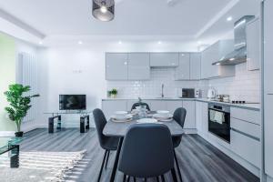 a kitchen with a table and chairs in a room at Brand New Modern 2 Bed in Didsbury in Manchester