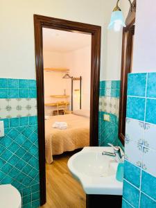 a bathroom with a sink and a bed and a mirror at Affittacamere Ciro's House in Olbia