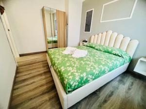 una camera da letto con un grande letto e un piumone verde di In centro, silenzioso e balcone a Sanremo