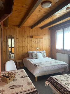 a bedroom with two beds in a room with wooden walls at Hotels Les Catrems & Le Montagnou in Orcières