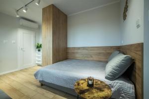 a bedroom with a bed with a table on it at WiguryTower Apartaments 63' in Łódź