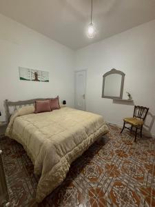 um quarto com uma cama grande e uma cadeira em Casa Centamore em Biancavilla