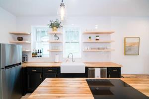 a kitchen with black cabinets and a white sink at The Mile High Escape in Curtis Park in Denver