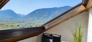 balcón con 2 sillas y vistas a las montañas en Suite Castel MeranO - panorama terrace and pool en Merano