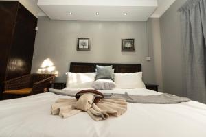 Un dormitorio con una gran cama blanca con una manta. en Mumses Guest House en Ramotswa