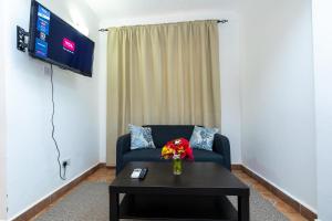 uma sala de estar com um sofá e uma mesa com flores em Sarges Hotel em Sere Kunda