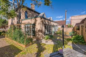 an old house with a garden in front of it at Woods Manor Walk to Downtown Built in 1887 in Denver